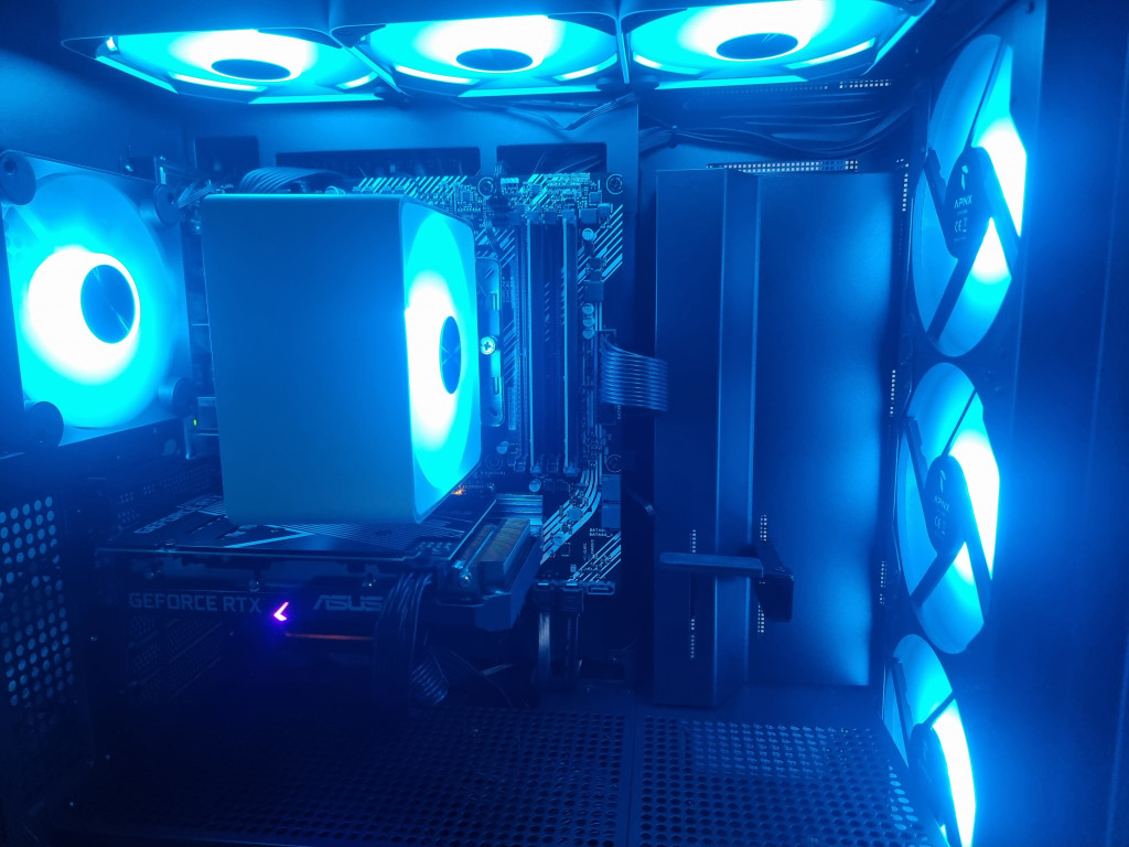 photo showing the inside of the PC case lit up in an electric blue from all 8 fans.