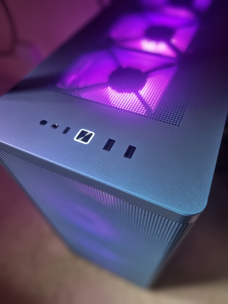 photo showing a view of the pc case from front top down. The case looks amazing and the fans are lit in a bright purple.