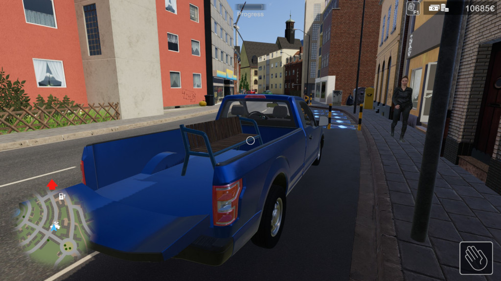 A blue pickup truck is parked on a street waiting to be loaded up with items.